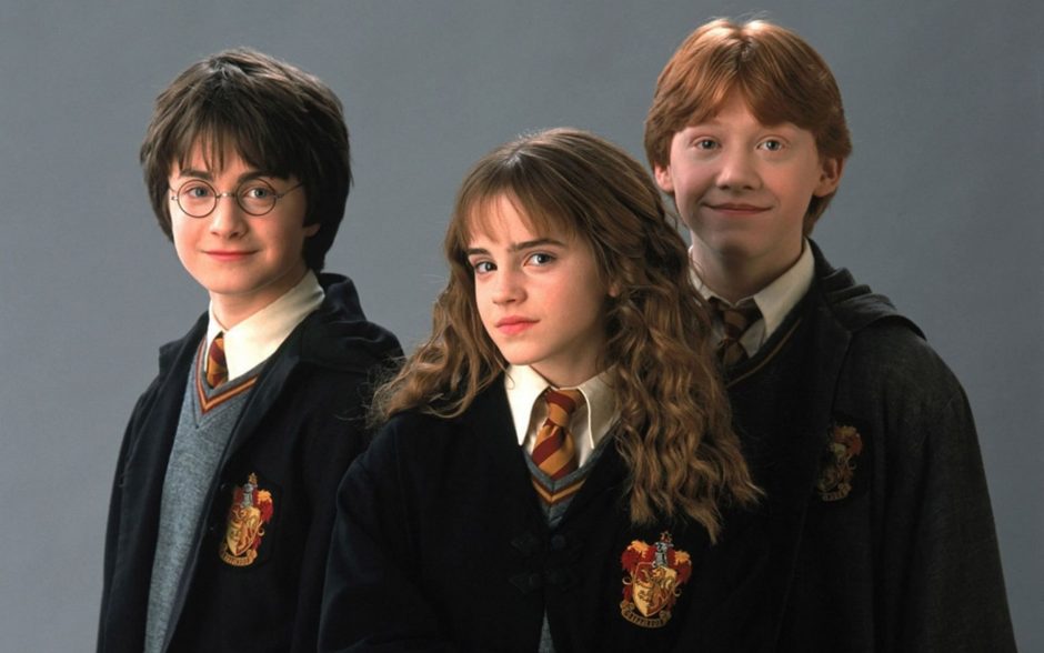 Harry, Hermione e Ron com os uniformes de Hogwarts