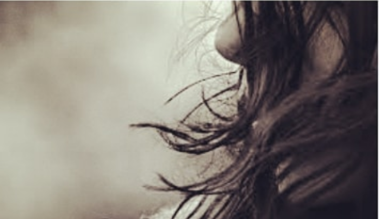 Garota_Reinventada garota olhando de lado, os cabelos esvoaçando ao vento