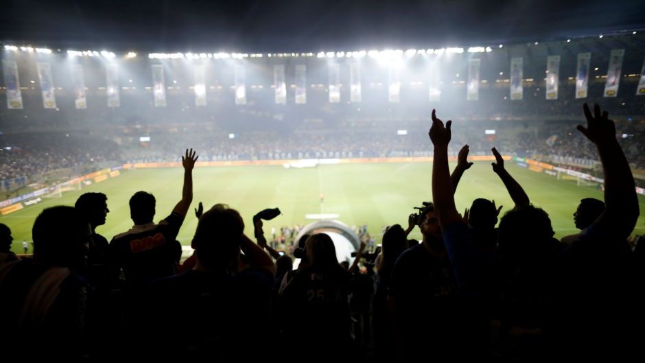 Foto do meio da torcida de uma partida de futebol